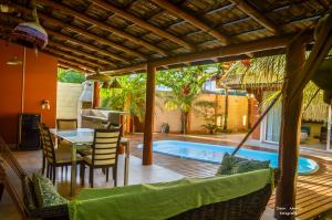 a patio with a table and chairs and a swimming pool at Casa de beira mar com piscina in Coruripe