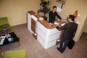 two men standing at a cash register in an office at Agropolog Hotel & Spa in Želino