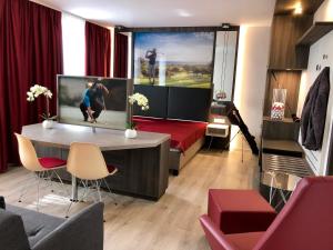 - un salon avec une télévision et un canapé dans l'établissement Star Apart Hotel Sachsenhausen, à Francfort-sur-le-Main