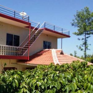 um edifício com uma varanda em cima em Nithin homestay, private 3bedrooms house,madikeri em Madikeri