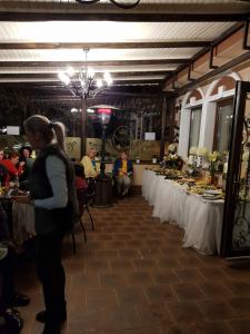 a woman standing in a room with tables of food at Boutique Tosca Regal in Bacău