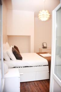 a bedroom with a white bed and a chandelier at Fullest Apartments in Lisbon