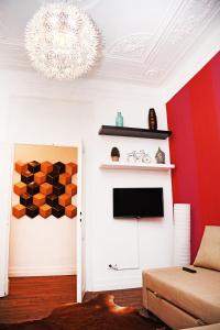 リスボンにあるフレスト アパートメンツの赤い壁のリビングルーム(テレビ付)