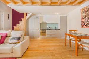 ein Wohnzimmer mit einem weißen Sofa und einem Tisch in der Unterkunft Graça Cozy Duplex in Lissabon