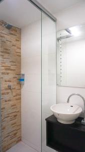bagno con lavandino e doccia in vetro di Hotel Funza Real a Funza