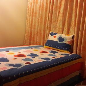 a bed with a pillow next to a curtain at Cáyamahue Guest House in Pucallpa