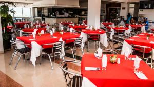 a restaurant with red and white tables and chairs at Hotel San José Plaza in Bucaramanga
