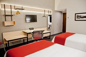a hotel room with two beds and a desk with a computer at City Express by Marriott Oaxaca in Oaxaca City