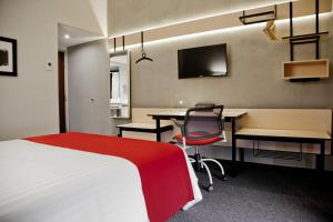 a hotel room with a bed and a desk and a computer at City Express by Marriott Oaxaca in Oaxaca City