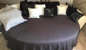 a bed with black and white pillows on it at Le nid d aigle in Éze