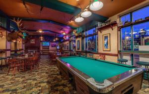 een pooltafel in een bar met tafels en stoelen bij Athabasca Hotel in Jasper