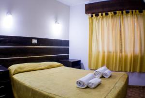 a hotel room with two beds with towels on them at San Remo Palace Hotel in Villa Gesell +30 photos