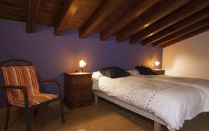 a bedroom with a large bed and a chair at Casa Rural Nazar in Nazar