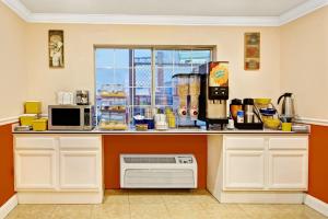 a kitchen with a counter with a microwave and a window at Days Inn by Wyndham San Antonio Airport in San Antonio