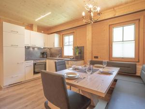 cocina y comedor con mesa de madera y sillas en Appartement Renate, en Sölden