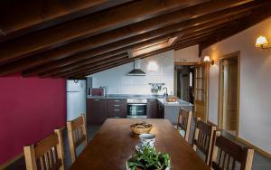 une cuisine avec une table en bois et des chaises ainsi qu'une salle à manger dans l'établissement Casa Rural Nazar, à Nazar