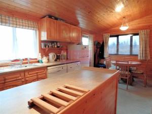cocina con armarios de madera y encimera de madera en Lodge 53 Aviemore Holiday Park en Aviemore
