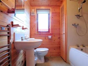 La salle de bains est pourvue d'un lavabo, de toilettes et d'une baignoire. dans l'établissement Lodge 53 Aviemore Holiday Park, à Aviemore