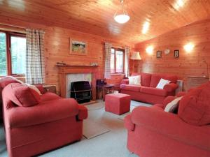 sala de estar con sofás rojos y chimenea en Lodge 53 Aviemore Holiday Park en Aviemore