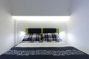 a bed with blue and white sheets and pillows at Boutique House Fiò in Ischia