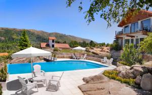a swimming pool with chairs and a house at Suites de la Colina in La Cumbrecita