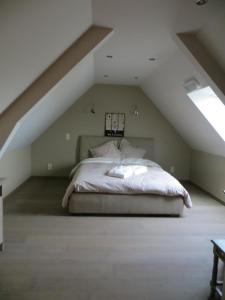 a bedroom with a bed in the attic at B&B 't Hannonshof in Nieuwpoort