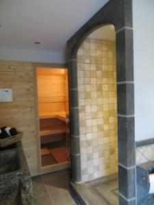 een badkamer met een inloopdouche naast een houten muur bij B&B 't Hannonshof in Nieuwpoort