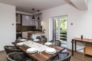 eine Küche und ein Esszimmer mit einem Holztisch und Stühlen in der Unterkunft Apartments Agape in Crikvenica