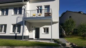 杜塞道夫的住宿－Apartment in Unterbach，白色的房子,阳台配有两把椅子