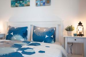 Un dormitorio con una cama azul y blanca con almohadas azules en Victoria Avenue Apartment en Bucarest