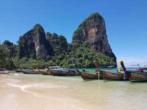 a group of boats sitting on the shore of a beach at Railay Village Resort in Railay Beach