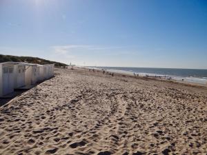 einen Sandstrand mit einer Reihe von Strandhütten in der Unterkunft Melroce Holiday Cottage 5504 in Bredene