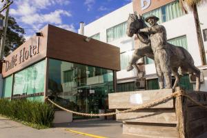 a statue of a man riding a horse in front of a building at Dalle Hotel in Bagé