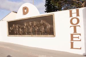 a sign with horses on the side of a building at Dalle Hotel in Bagé