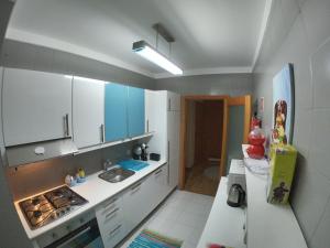 a small kitchen with a sink and a refrigerator at Sea & City in Leça da Palmeira