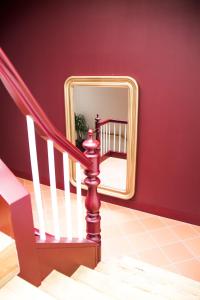 a staircase with a mirror in a red wall at Banho de Mar in Póvoa de Varzim