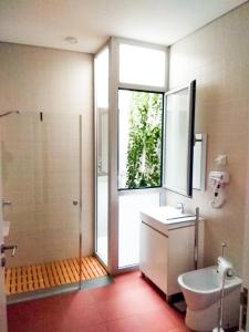 a bathroom with a shower and a sink and a toilet at Banho de Mar in Póvoa de Varzim
