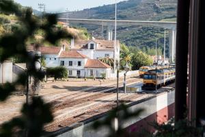 a train is on the tracks at a train station at Bugalha My Loft Douro 7 in Peso da Régua