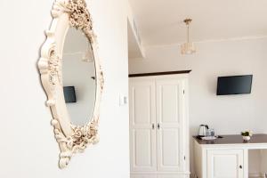 um espelho branco pendurado numa parede num quarto em Hotel Merty em Constança