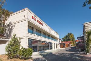 a white building with a red sign on it at Hotel Merty in Constanţa