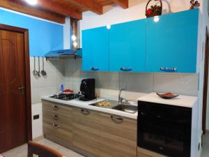 a kitchen with blue cabinets and a sink at Da Rosy in Partinico