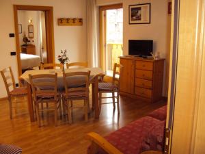 a dining room with a table and chairs and a television at HOTEL La Locanda in Pinzolo