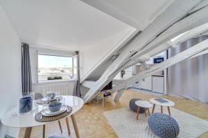 a room with a table and chairs and a staircase at Les Mansardes du Roi in Versailles