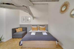 a bedroom with a bed and a couch at Les Mansardes du Roi in Versailles