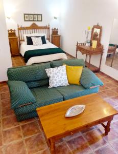 Hotel Palacio Buenavista في بيلمونت: غرفة معيشة مع أريكة وسرير