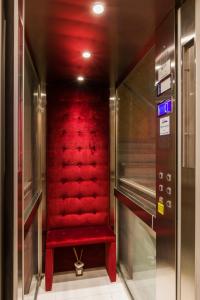 a red elevator with a red seat in a building at VRooms All'Angolo Del Duomo in Florence