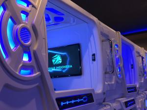 a video game system with a screen in a room at Passgo Digital Airport Terminal 3 Soekarno Hatta in Tangerang