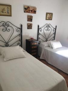 a bedroom with two beds and a night stand with twoitures at La Algazara in Villamartín