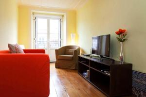 a living room with a couch and a television at Apartment Baixa/Chiado view Castle in Lisbon