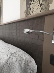 una camera da letto con testiera con tubo di Hotel Plaza a Desenzano del Garda